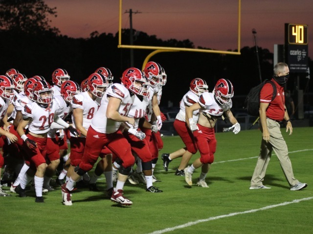 Football players running onto field at start of the game