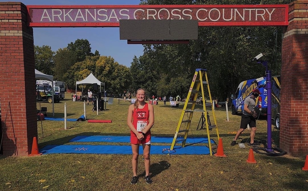 Student standing in front of finish line at race.