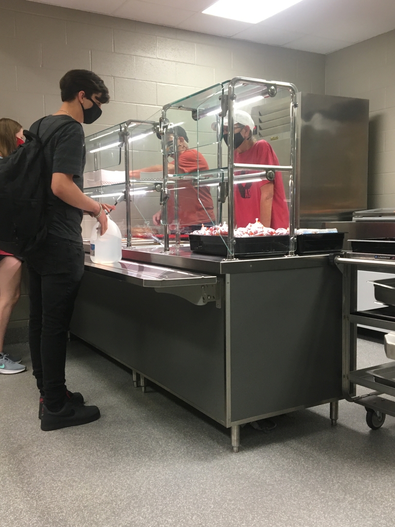Two lunch servers serving students food