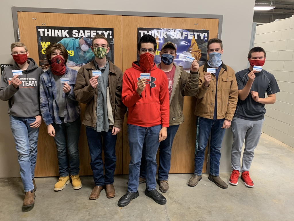Students showcasing their OSHA certification cards.