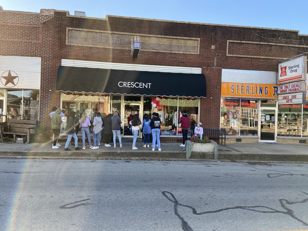Students studying the front of Crescent Store