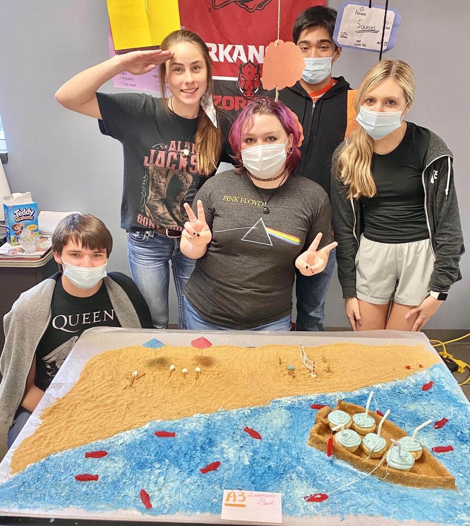 Students standing behind their sand and ocean cupcake creation