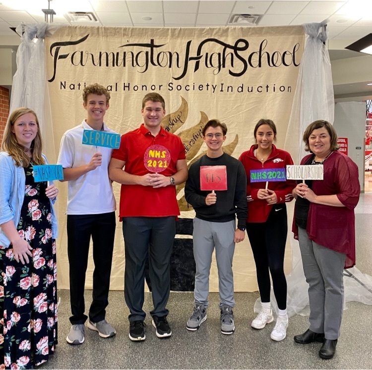 NHs officers & sponsors pose in front of a background that says Farmington NHS