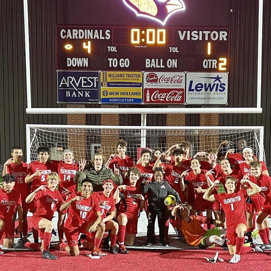 boys soccer team posing at home field in a previous game