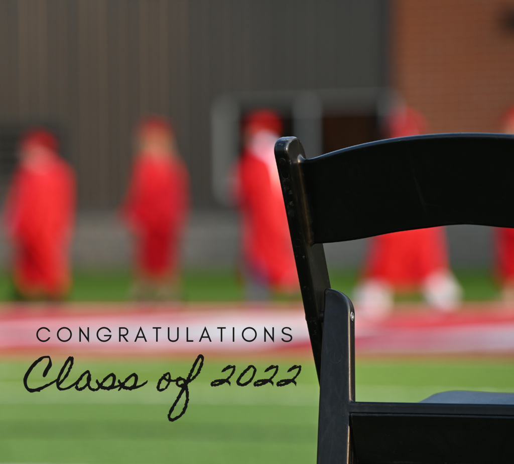 picture of a chair in the foreground with graduates walking in the background. text says "congratulations class of 2022"