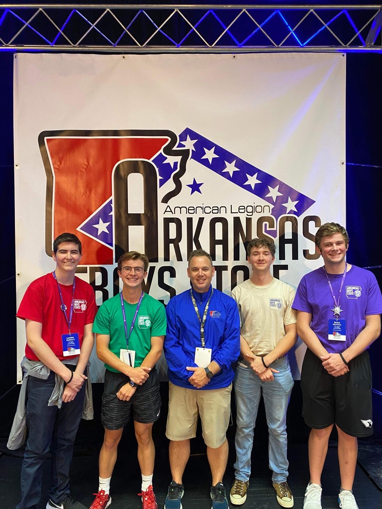 boys standing in front of Arkansas Boy State logo