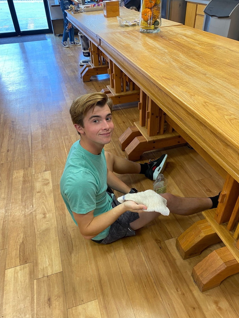 student cleaning a table