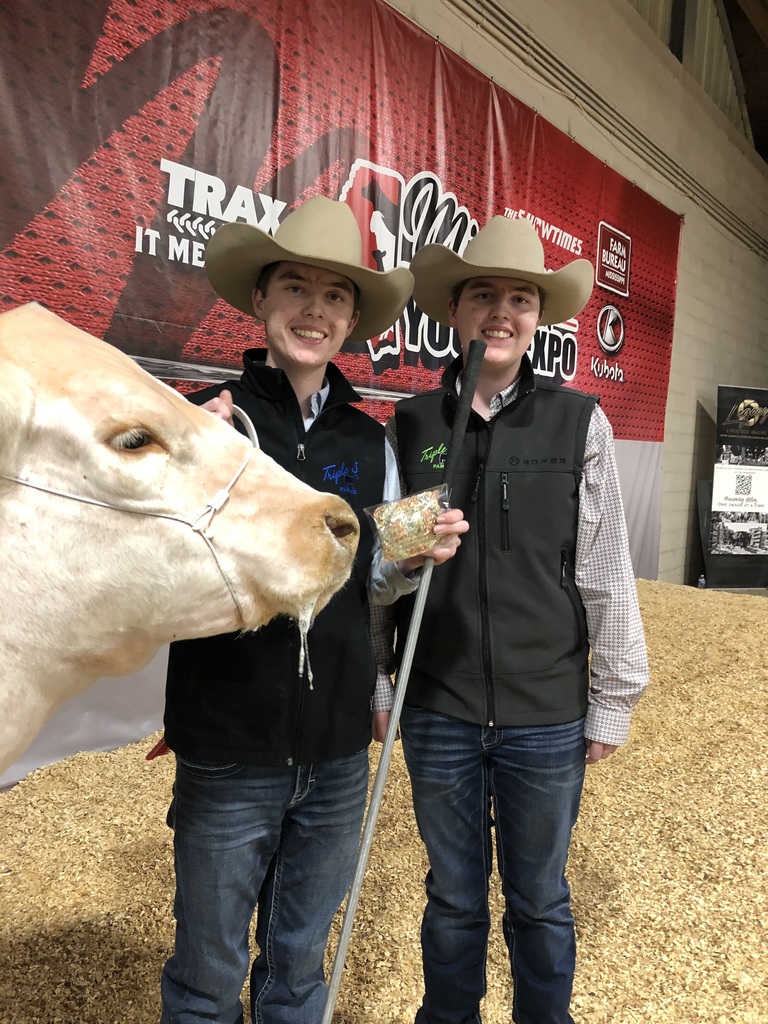 two students posing with their steer