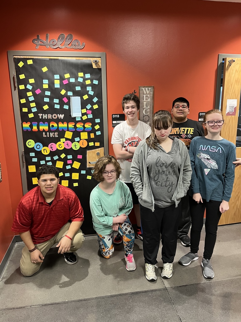 students posing in front of their kindness classroom door