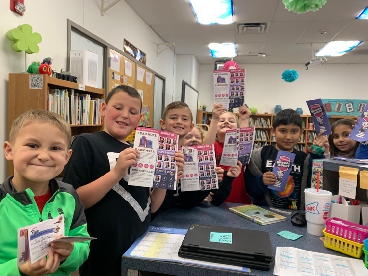 a group of student hold up their braums book buddy booklets