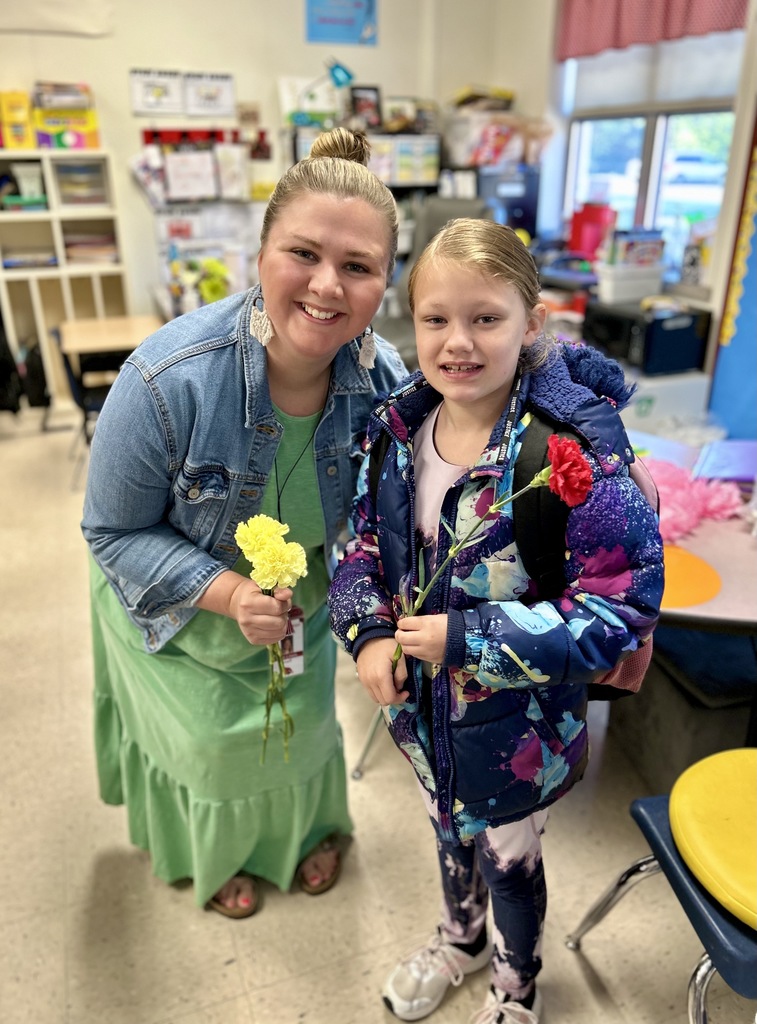 Mrs. Lewis holding a flower given to her by a student