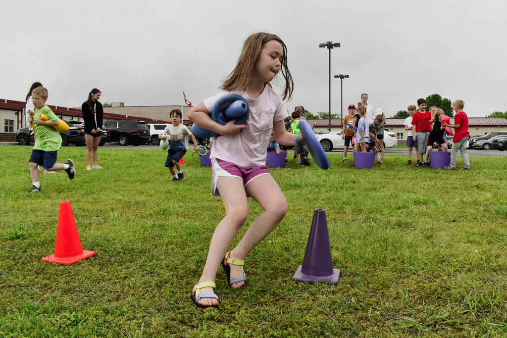 A student runs around a cone during field day
