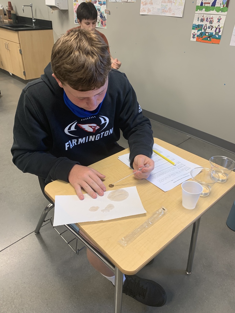 a close up of a student doing a lab at his desk