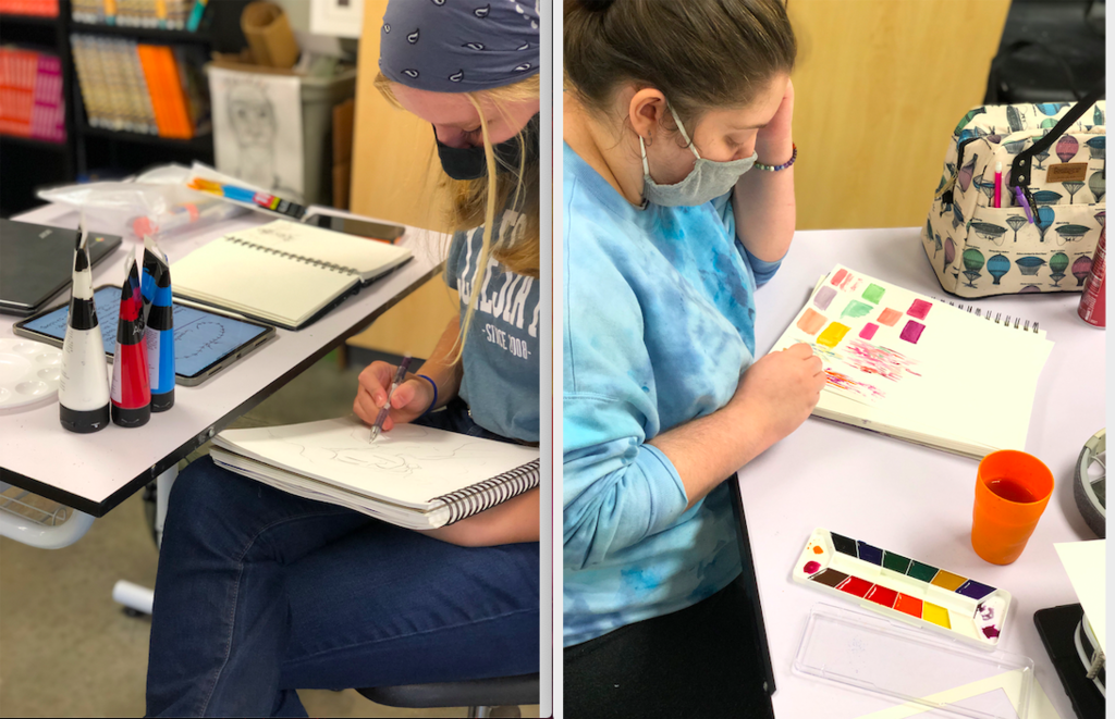 Two students drawing in sketchbooks